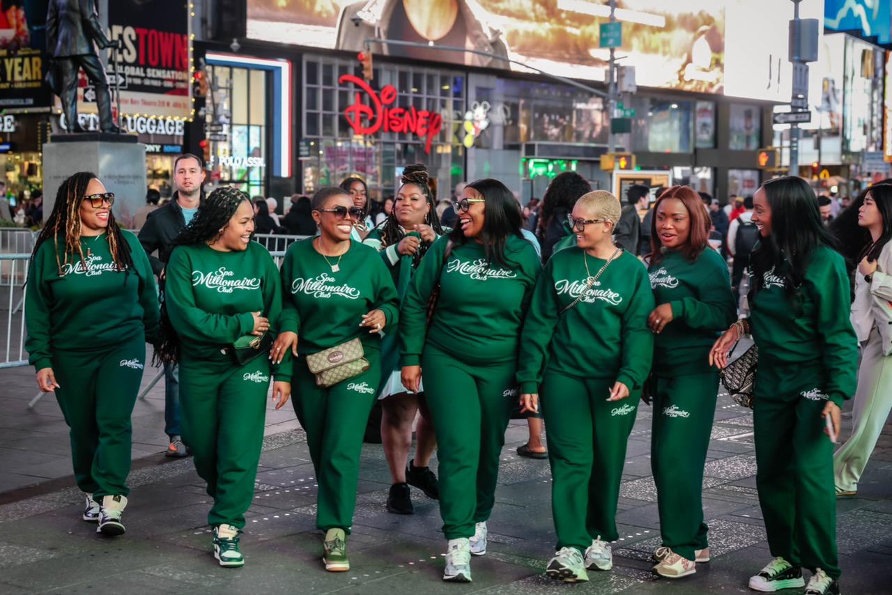 The tribe walking through Times Square in matching Spa Millionaire Club green